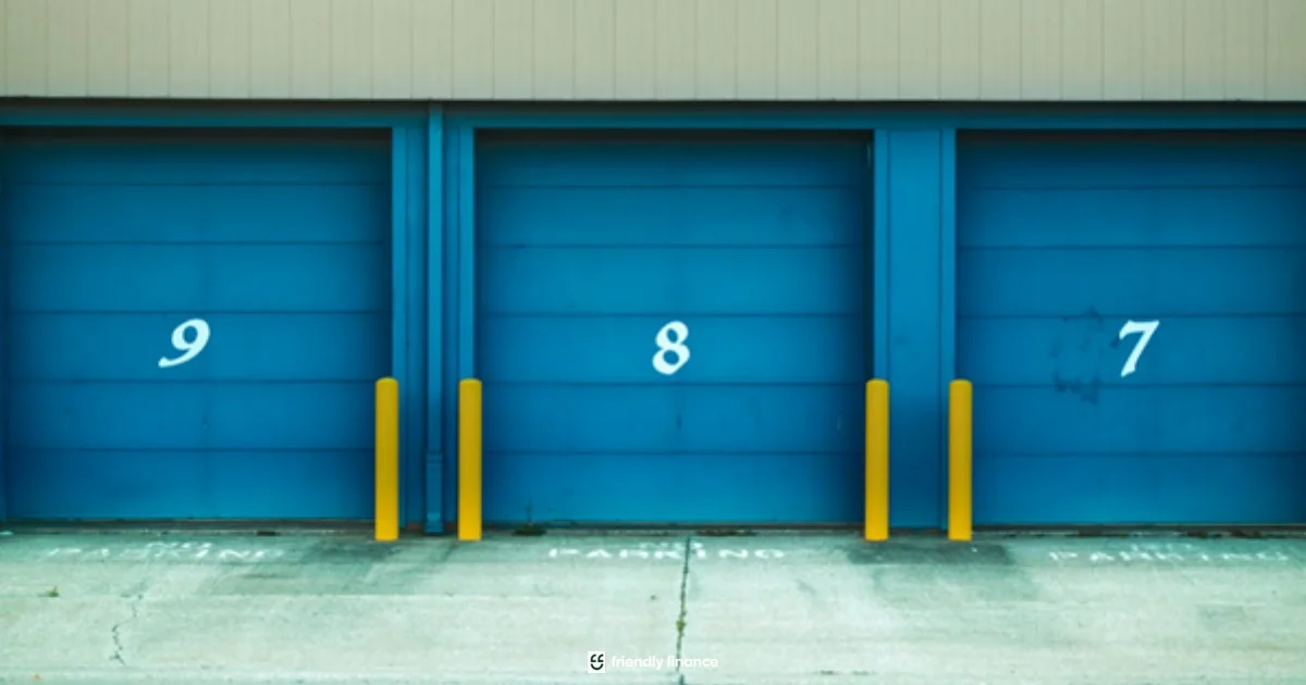 The exterior of a self-storage facility, showing three blue garage-style doors numbered 9, 8, and 7, with yellow bollards in front.