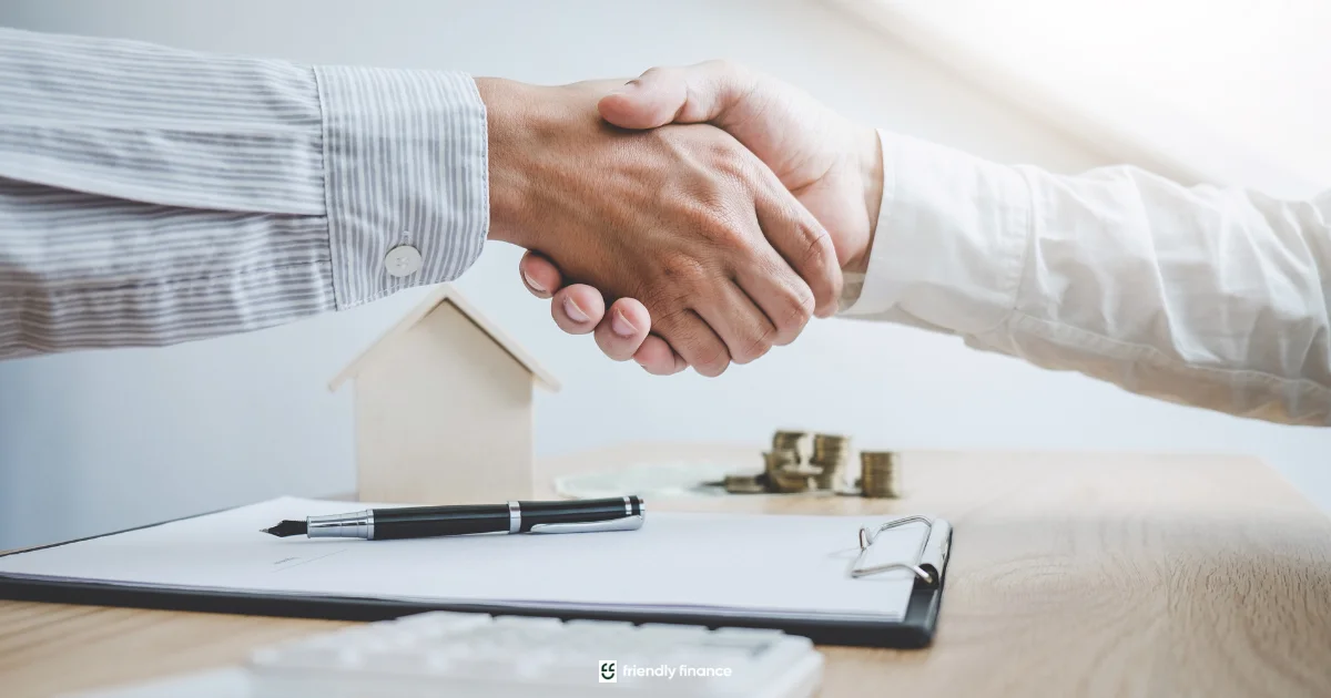 Handshake agreement between client and loan broker with house model on desk.
