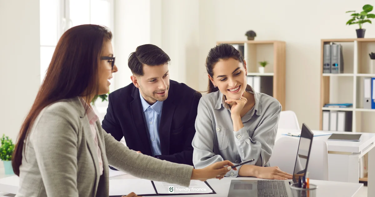 Financial advisor discussing loan options with a couple in a modern office.