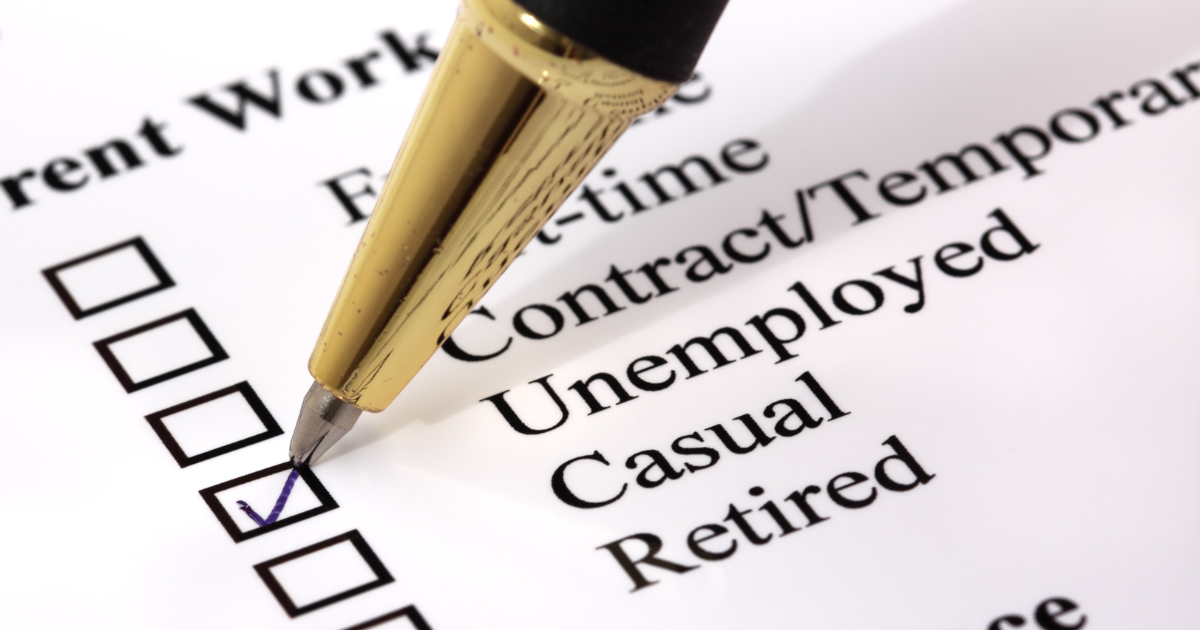 A close-up view of a gold and black pen ticking a checkbox on a "Current Work" questionnaire listing options for Full-time, Contract, Unemployed, Casual, and Retired status.