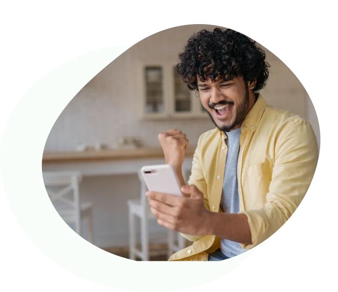 Man celebrating with Australian cash while looking at smartphone